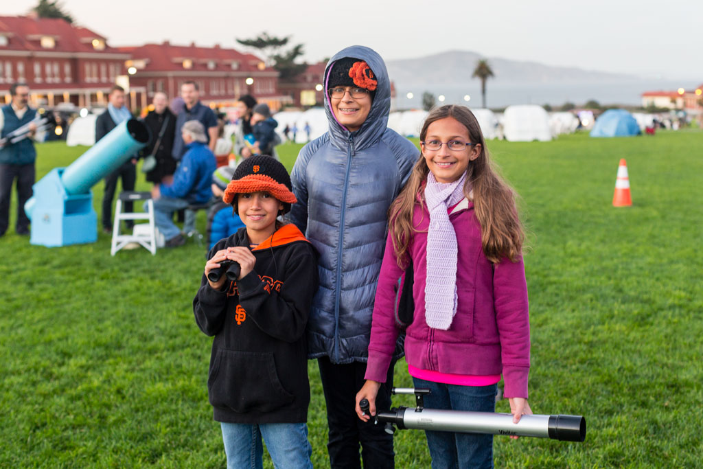 Three kids with binoculars and telescope