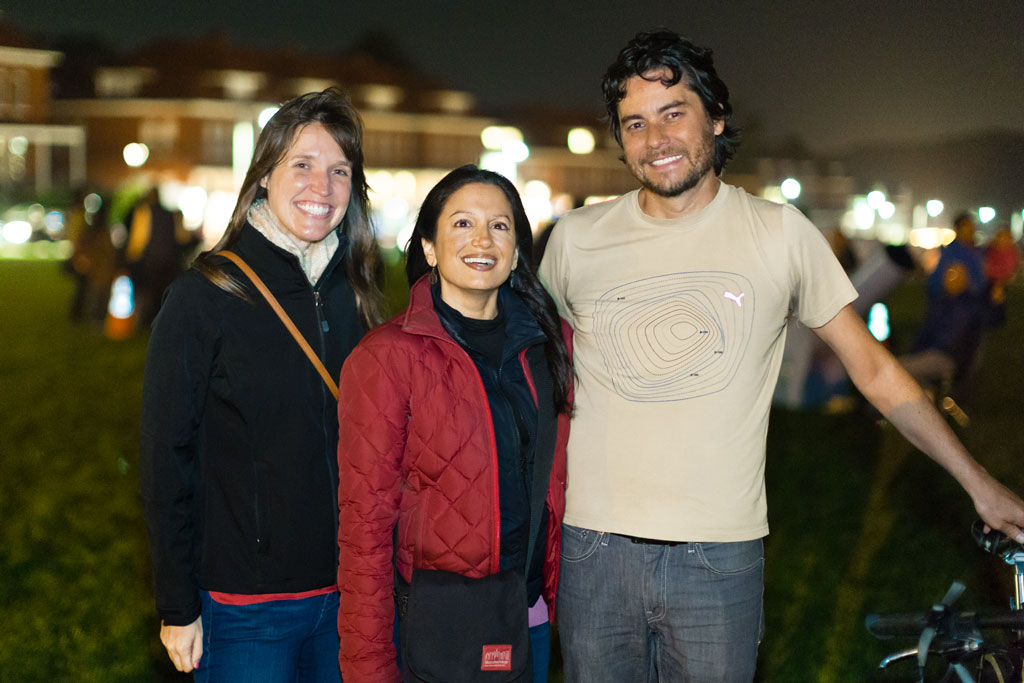 A couple women and man group photo at night