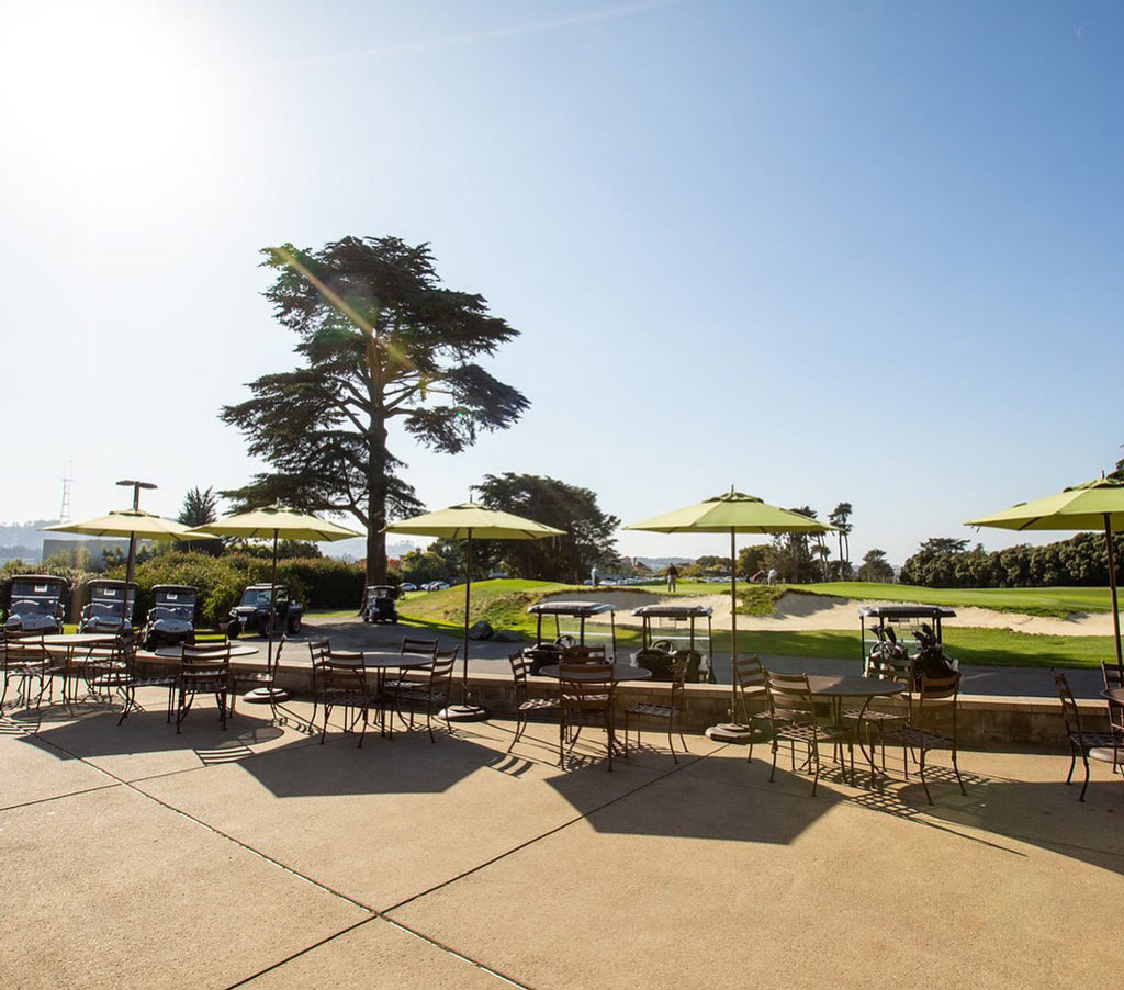 Outdoor dining patio with umbrellas with golf course views