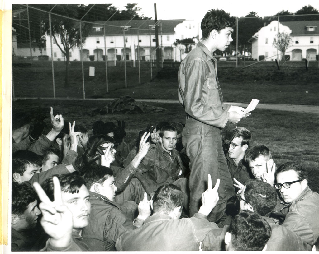 Man standing in the middle of sit-down protesters