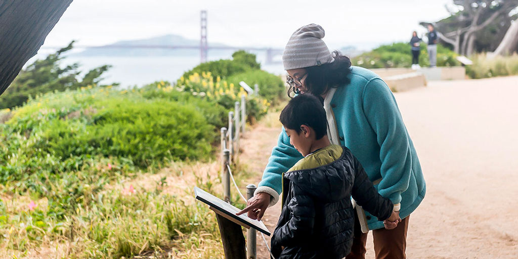 A family checks out a StoryWalk at Lands End in San Francisco.