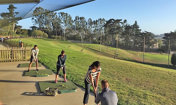 Golfers lined up at outdoor golf range