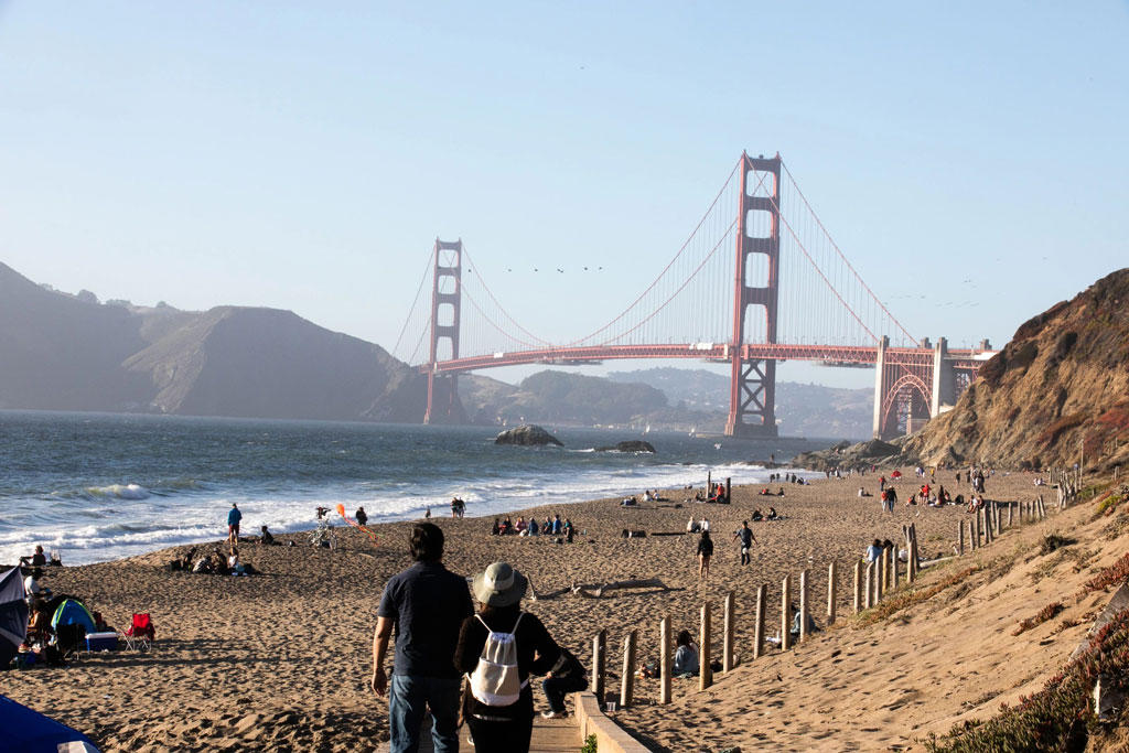 Visitors at Baker Beach with Golden Gate Bridge in background