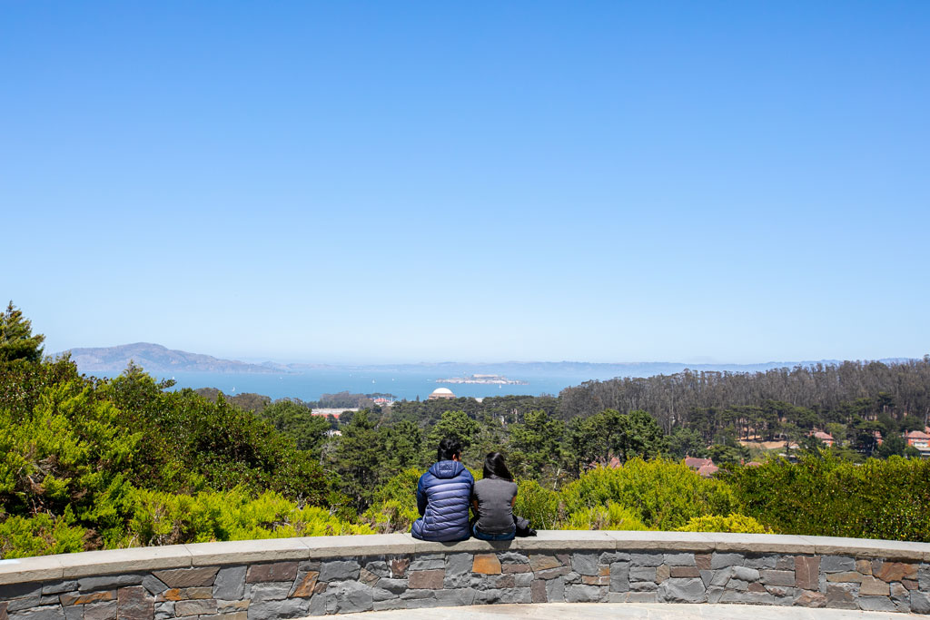 A couple visitors sitting looking outward at Inspiration Point Overlook