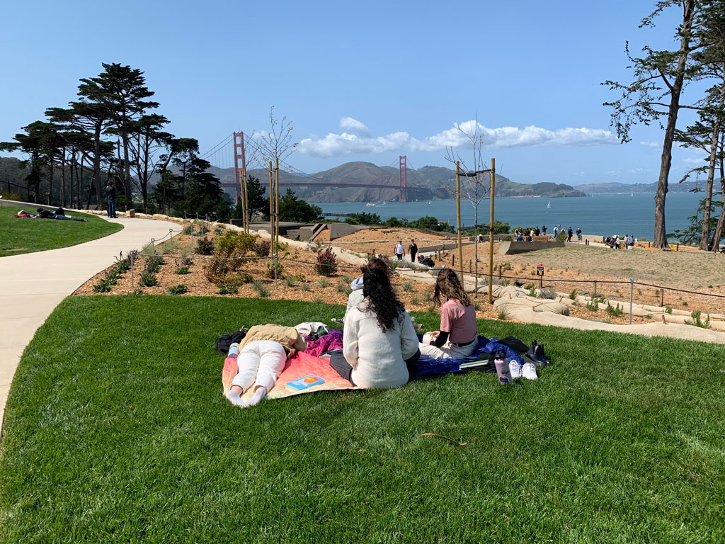 Group of picnickers on blanket on Battery Bluff lawn with Golden Gate Bridge views