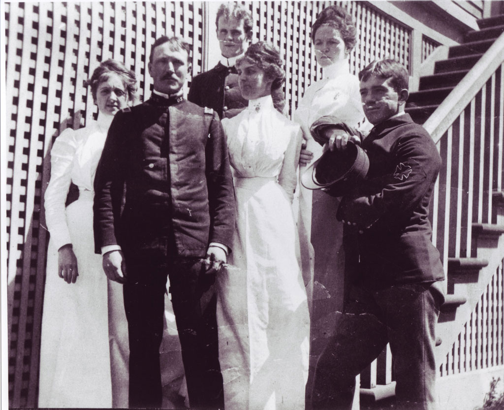 Six men and women of hospital staff posing for photograph on stairs