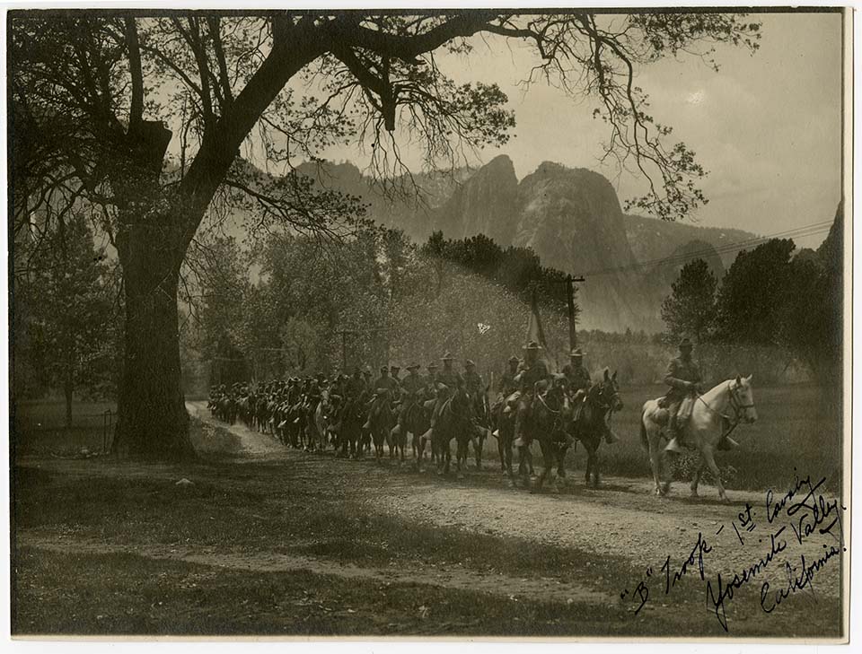 Troops on horses on trail with Yosemite mountains in the background