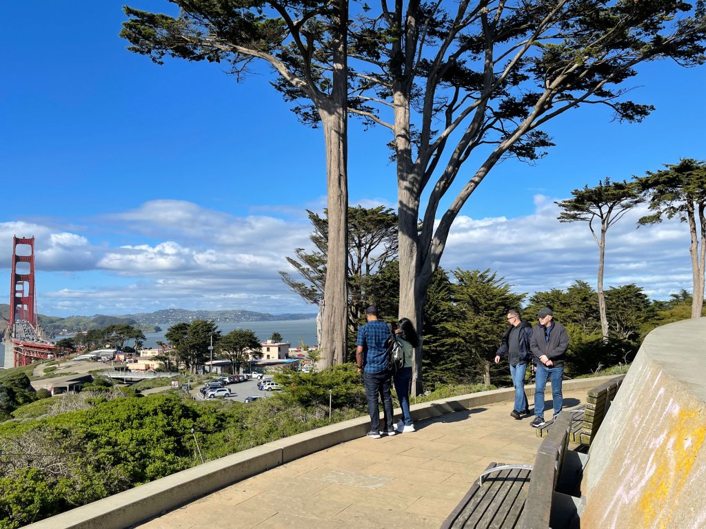Several people admiring the view at the Golden Gate Overlook in the Presidio of San Francisco.