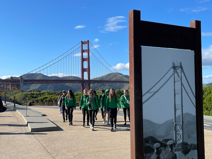 Group of people standing with Golden Gate Bridge behind them