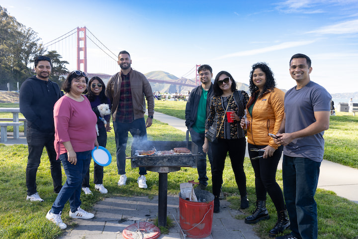 A large family grilling at Crissy Field West Bluff Picnic Area with the Golden Gate Bridge in the background. Photo by Myleen Hollero.