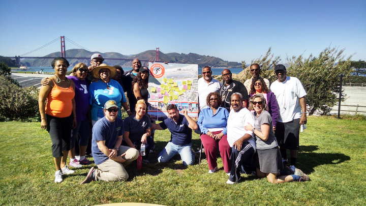 A group of people who participated in a Presidio Tunnel Tops planning tour standing on a lawn.