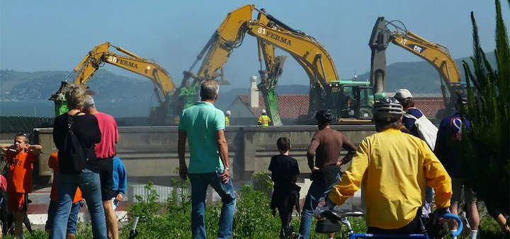 Several people watch as the Doyle Drive highway is demolished.