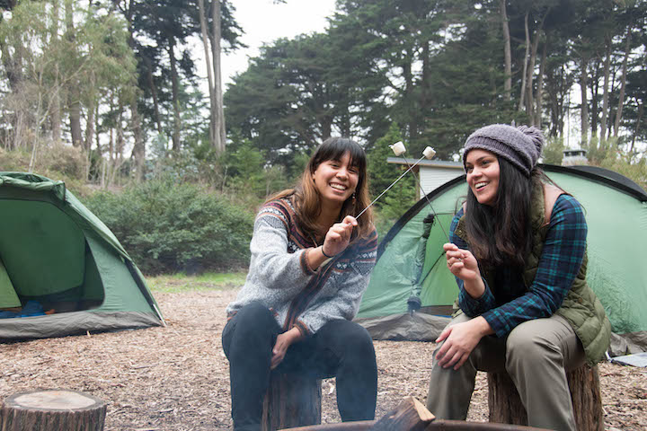 Two women making s’mores at Rob Hill Campground in the Presidio.