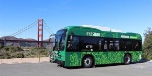 Green Presidio GO electric shuttle bus parked in front of Golden Gate Bridge