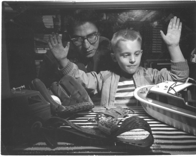 Black and white photo with boy looking at toys, December 4, 1962.