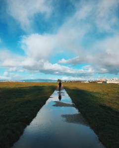 Crissy Field pathway after rains with a person walking.