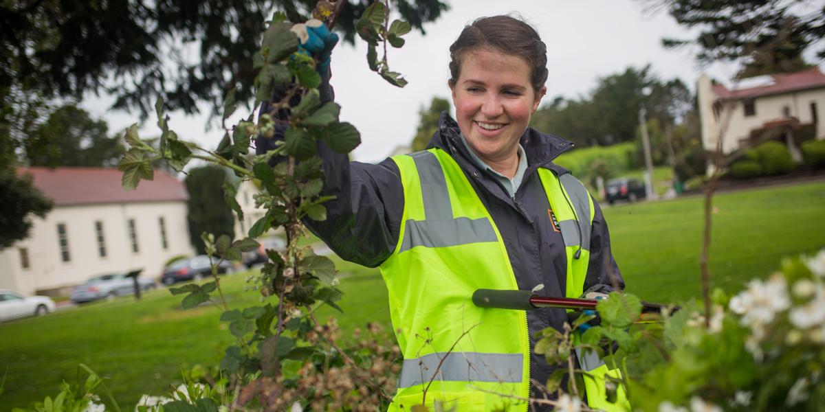 Woman in a yellow vest working at a volunteer event.