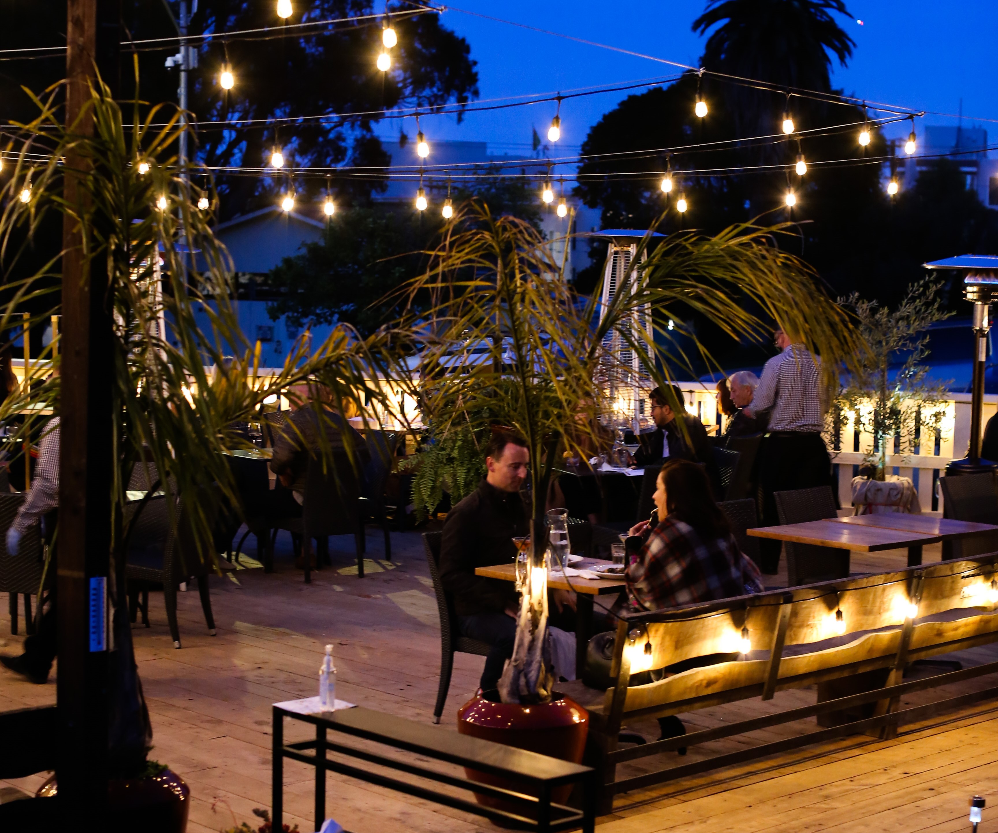 Couple enjoying a dinner under twinkle lights at Sessions