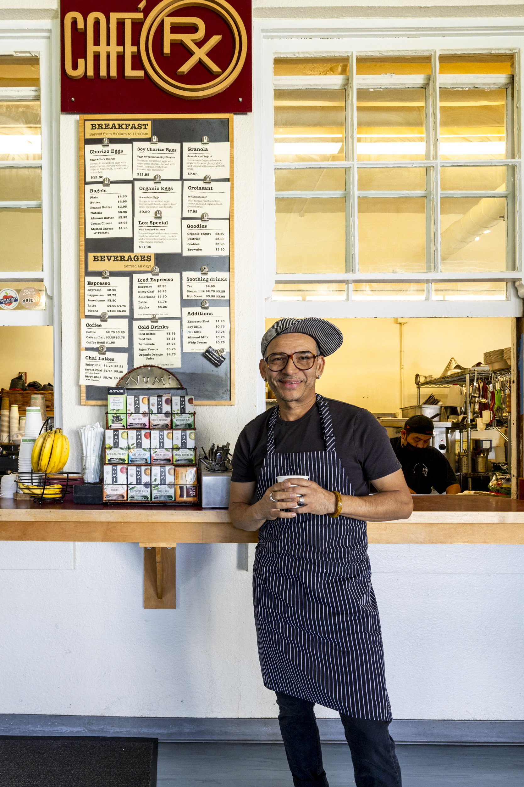 Chef and owner of Cafe RX, Rogelio Colindres, standing in front of the window where customers can order food.