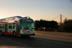 Muni bus on Mason Street at Crissy Field, with the Golden Gate Bridge in the background.