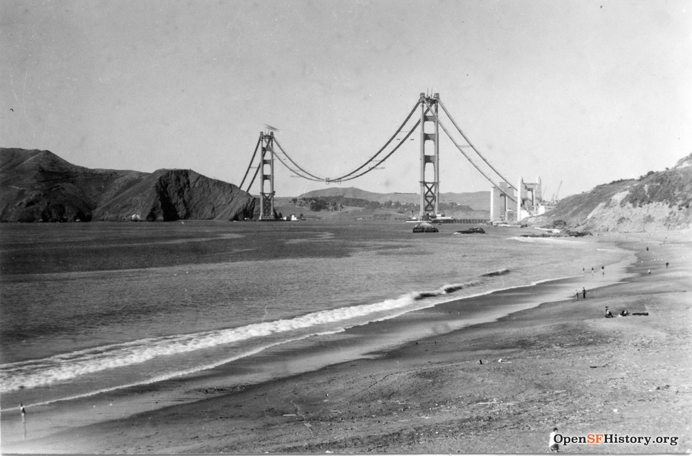 Black and white image of Golden Gate Bridge during construction with the towers up but not the road.