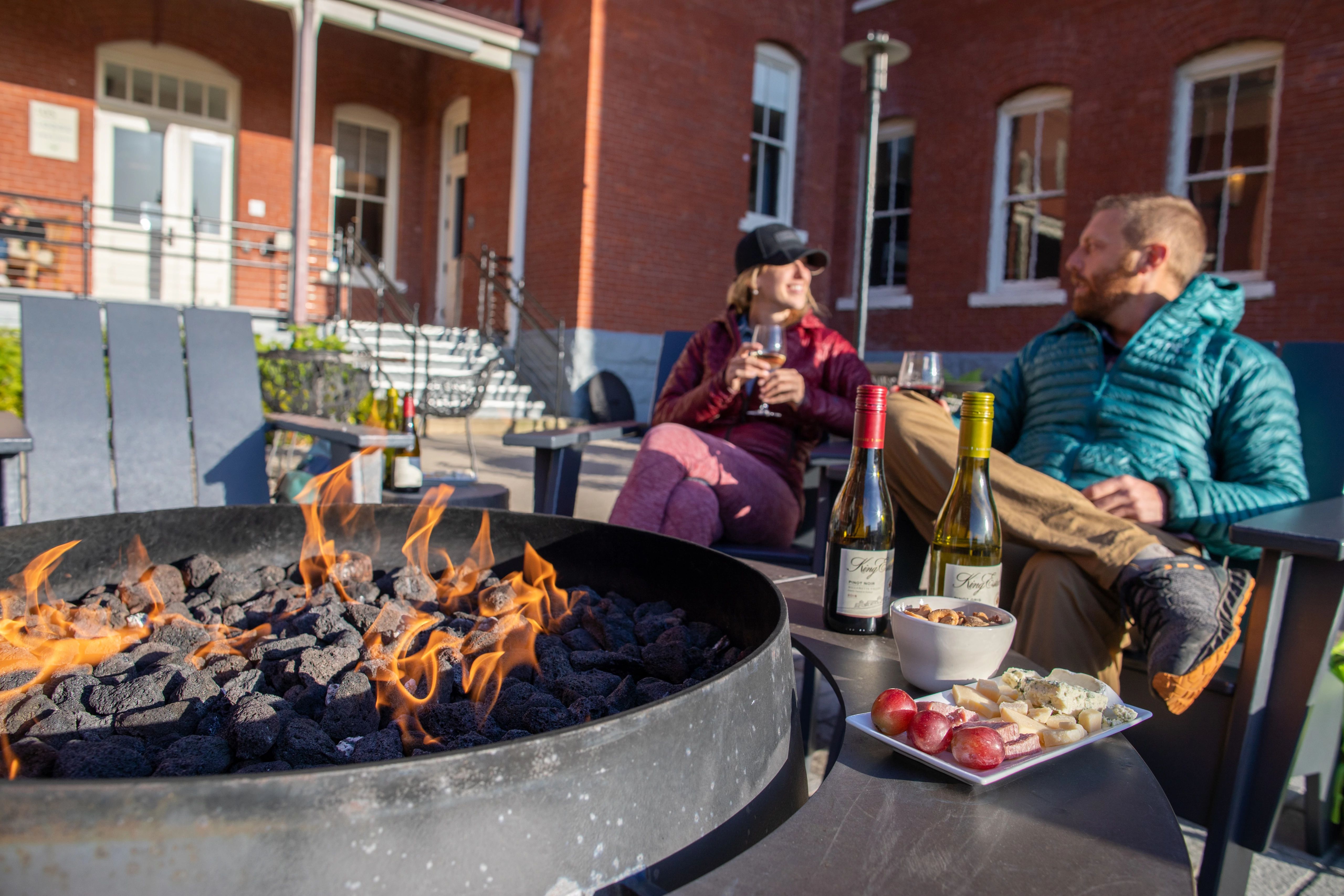 people enjoying wine by a fire