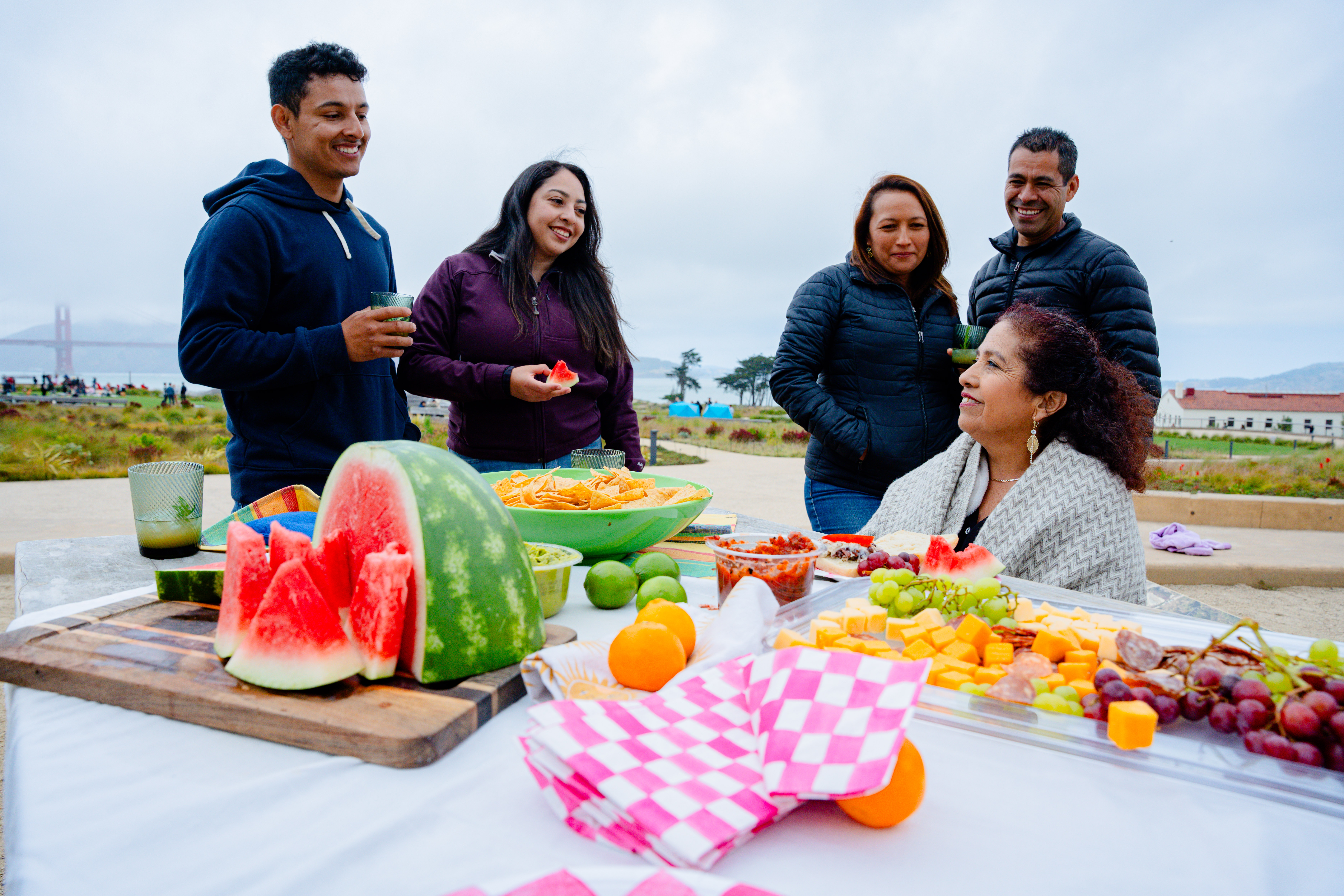 Family enjoying a fruit spread at the Presidio Tunnel Tops with the Golden Gate Bridge in the background