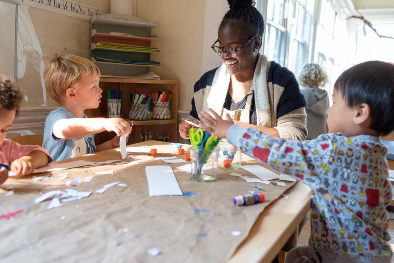 Teacher and students working at a table