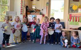 Group of children lined up showing artwork at Serra Preschool