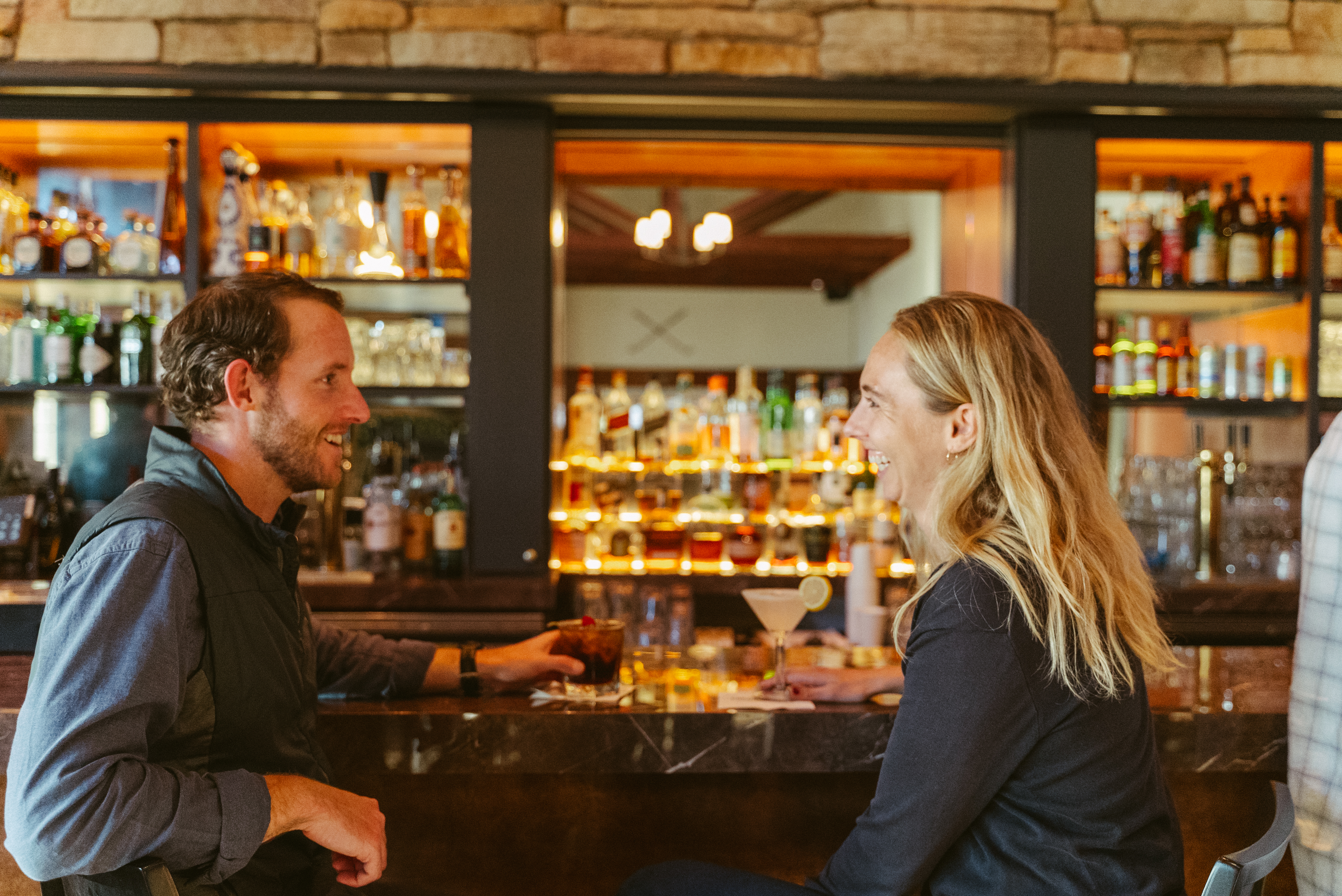 man and woman having a drink together at the bar at the Presidio Golf Course