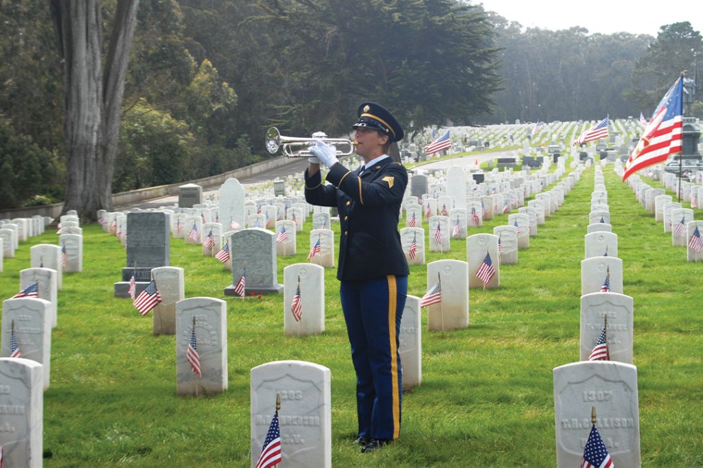 Man plays bugle at a ceremony.