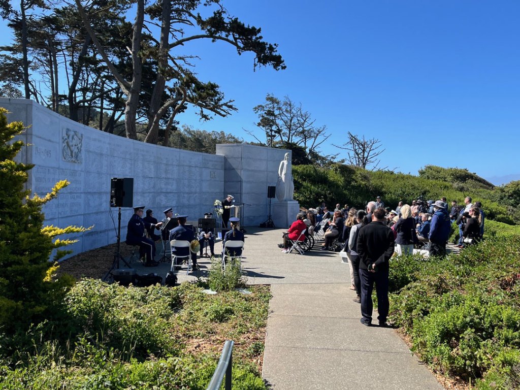 People attend a ceremony at a Memorial