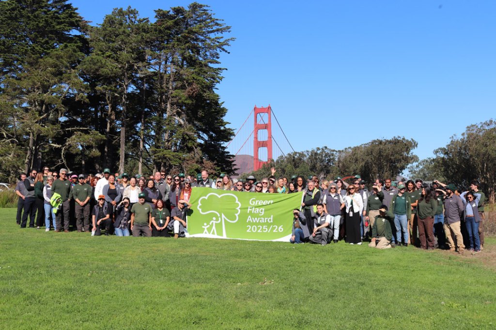Large group photo holding a flag.