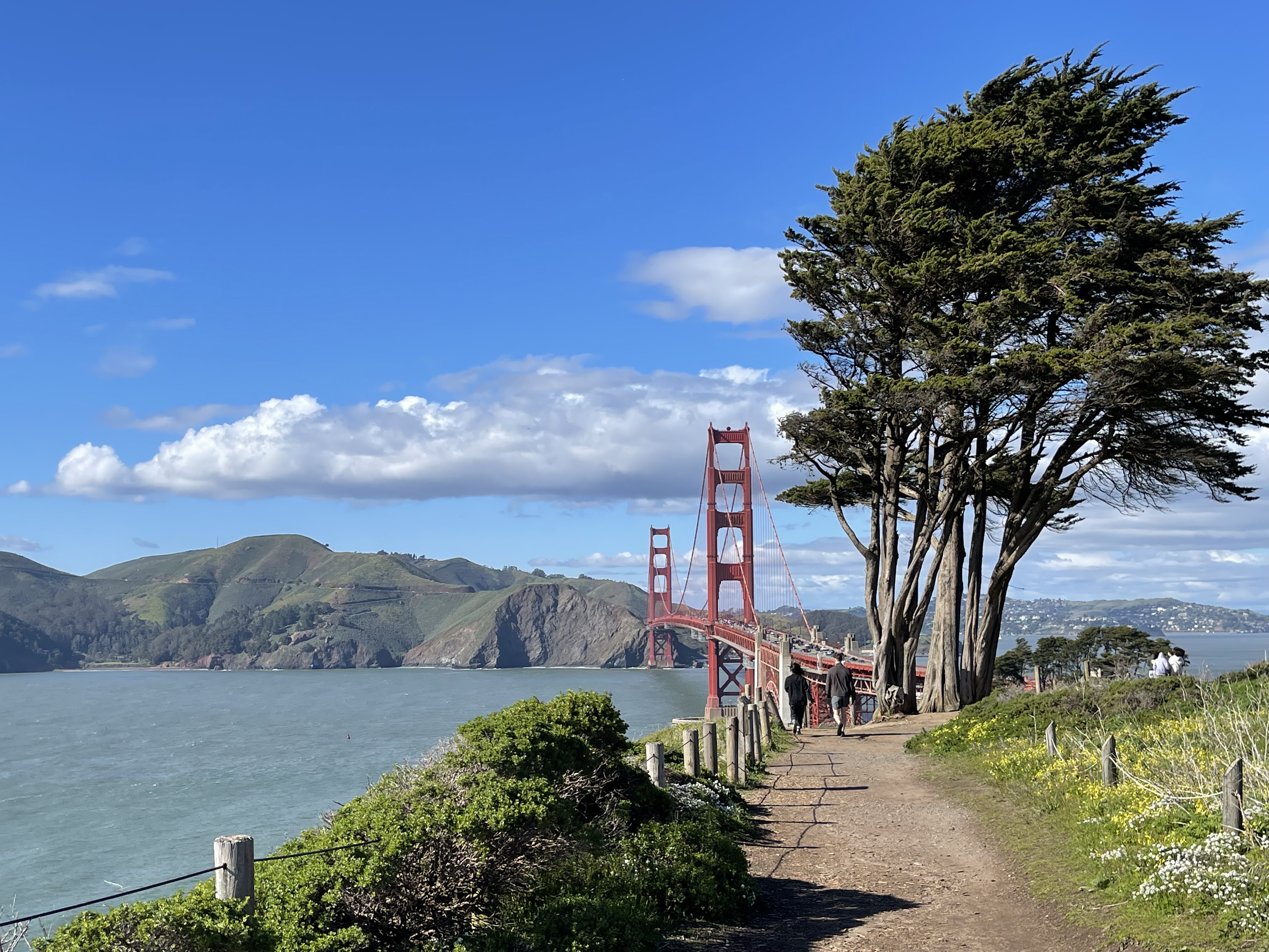 Couple walking out on the Bay Area Ridge Trail towards the Golden Gate Bridge,
